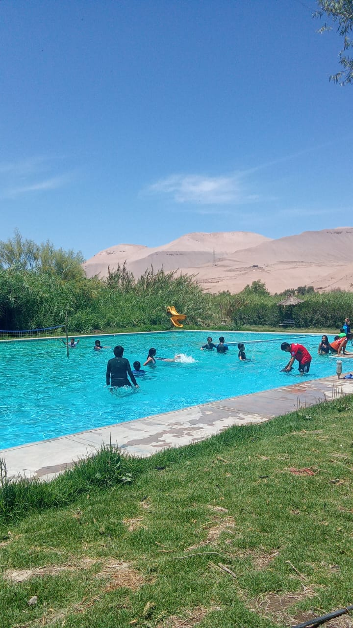 Viajeros disfrutando una piscina entre paisajes
